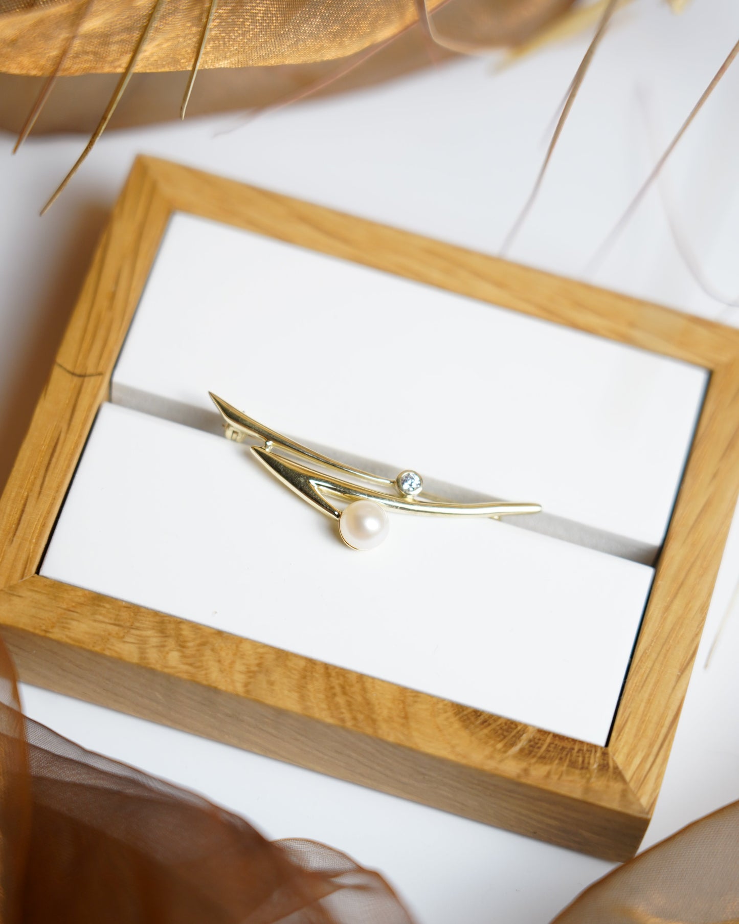 „Contemporary Wave“ – Brosche aus 333/- Gelbgold mit Zuchtperle und Zirkoniastein