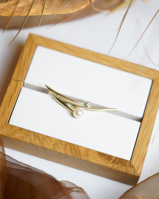 „Contemporary Wave“ – Brosche aus 333/- Gelbgold mit Zuchtperle und Zirkoniastein