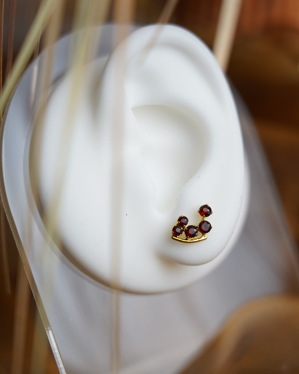 Crimson Vine Ohrstecker aus 333/- Gelbgold mit mehreren facettierten roten Granatsteinen in geschwungener Anordnung.