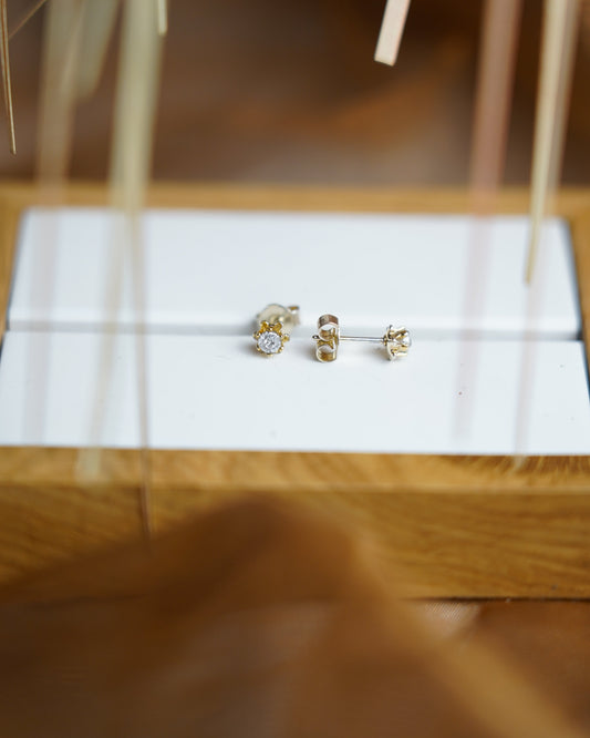 Golden Bloom Ohrstecker aus 585/- Gelbgold mit funkelndem Diamant in filigraner Krappenfassung.