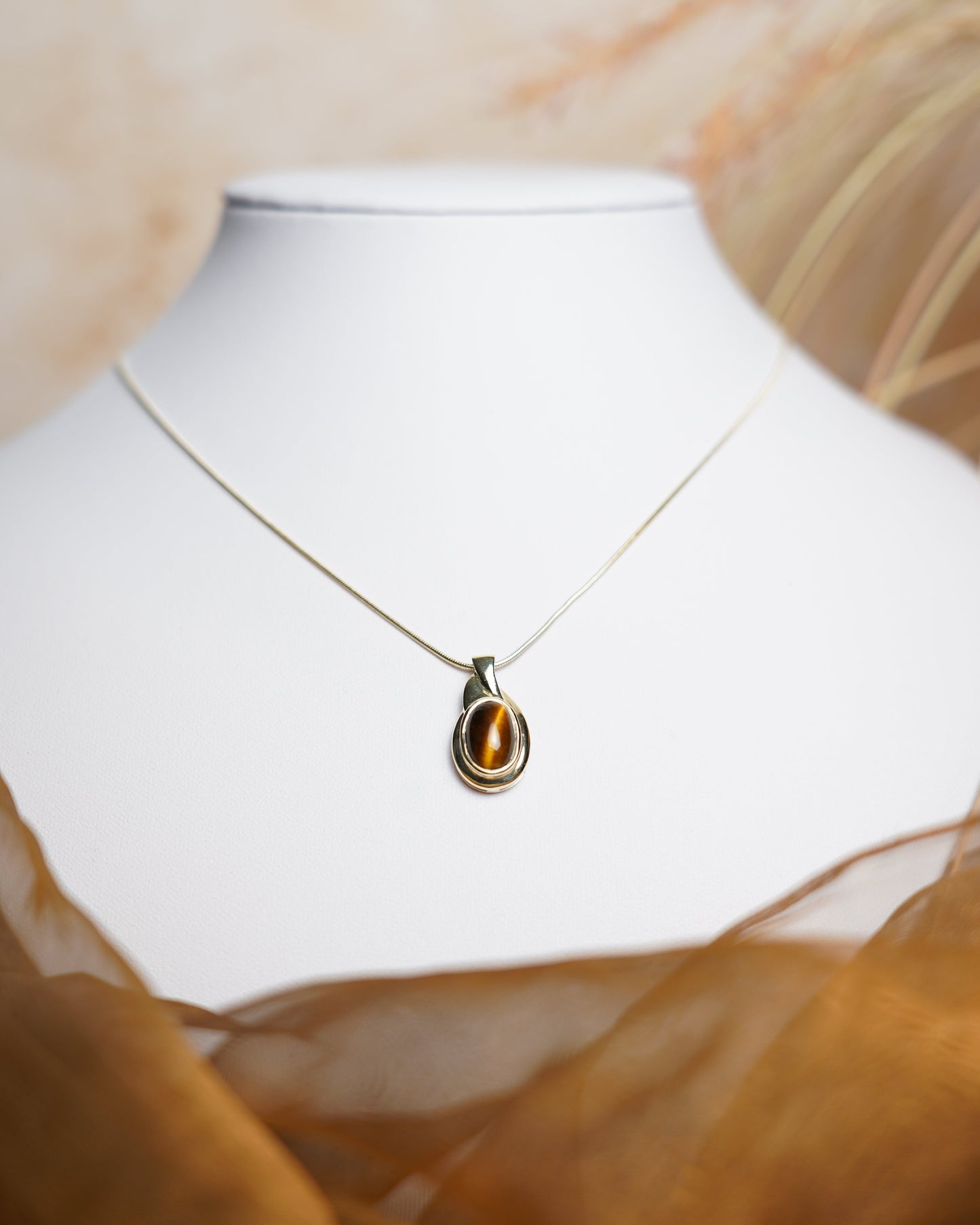 Halskette aus 585 Gelbgold mit ovalem Tigerauge-Anhänger in eleganter, zeitloser Fassung.