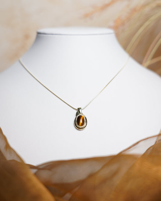 Halskette aus 585 Gelbgold mit ovalem Tigerauge-Anhänger in eleganter, zeitloser Fassung.