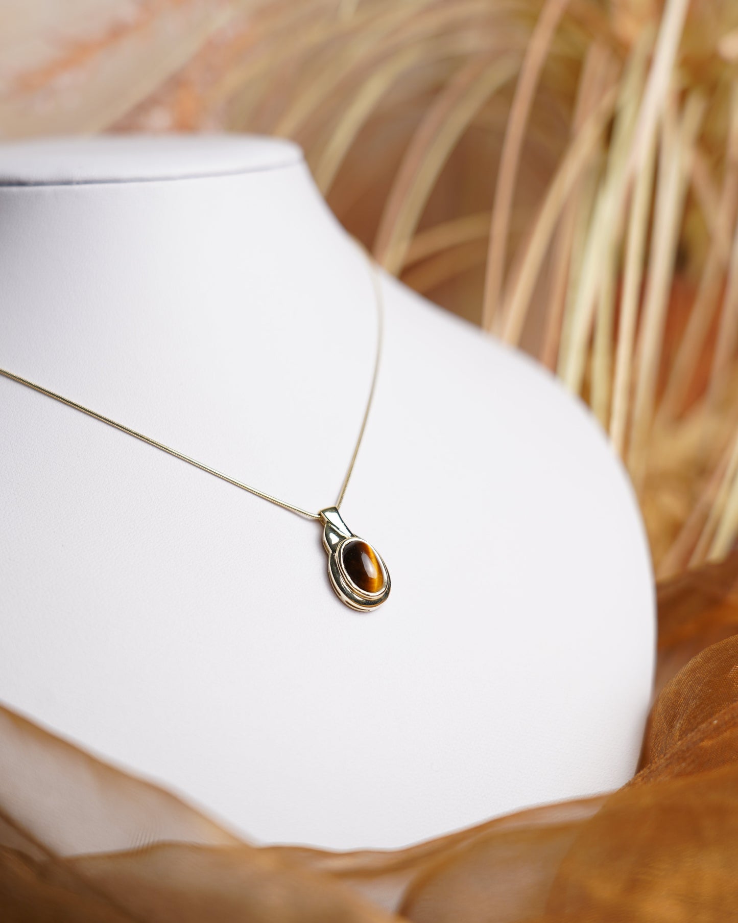 Halskette aus 585 Gelbgold mit ovalem Tigerauge-Anhänger in eleganter, zeitloser Fassung.