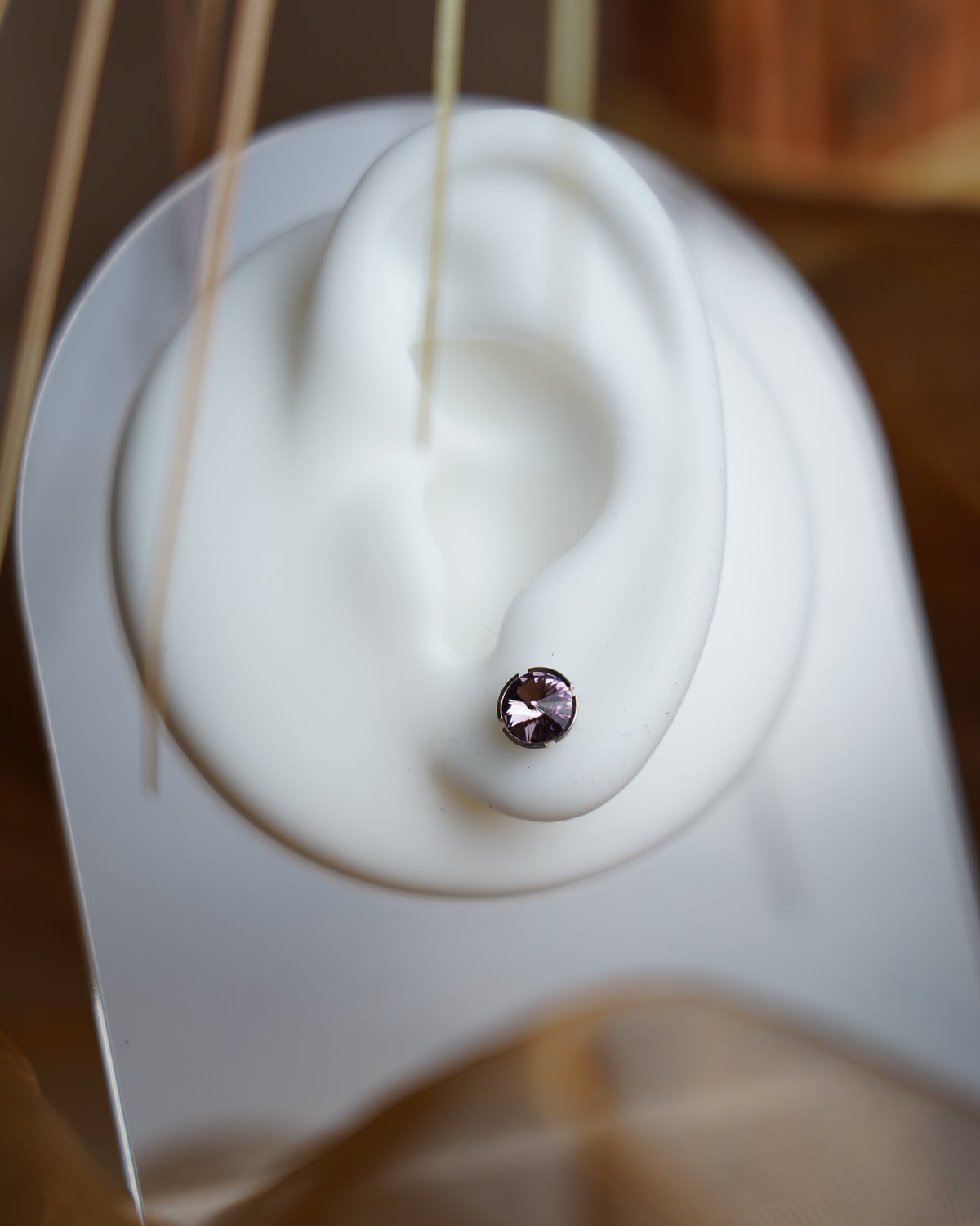 Lilac Spark Ohrstecker aus 925/- Sterlingsilber mit runden, facettierten Glassteinen in zartem Lila, auf weißem Schmuckdisplay präsentiert.