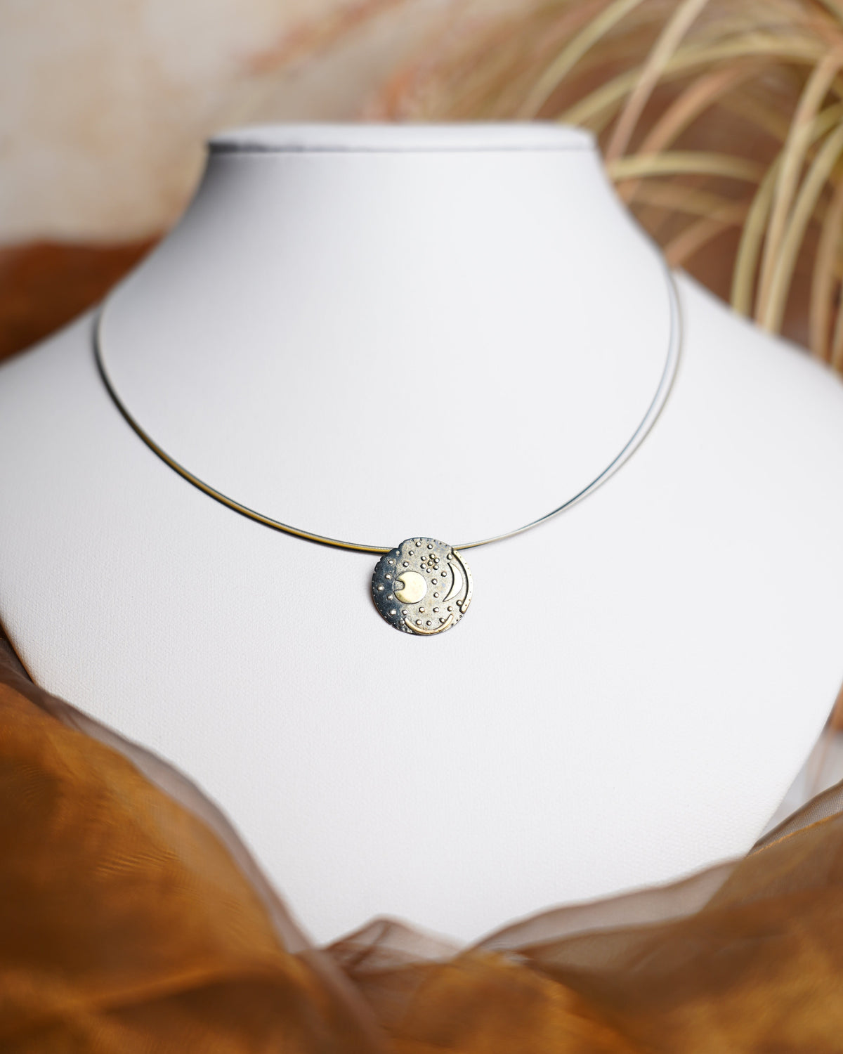 Nebra Sky Halskette aus 925/- Sterlingsilber mit rundem Anhänger nach dem Motiv der Himmelsscheibe von Nebra, geschwärzt und teilvergoldet.
