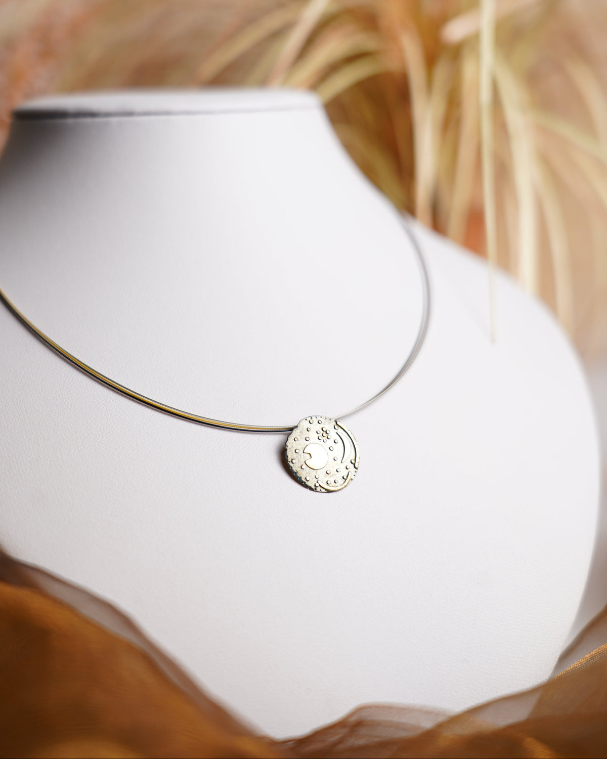 Nebra Sky Halskette aus 925/- Sterlingsilber mit rundem Anhänger nach dem Motiv der Himmelsscheibe von Nebra, geschwärzt und teilvergoldet.