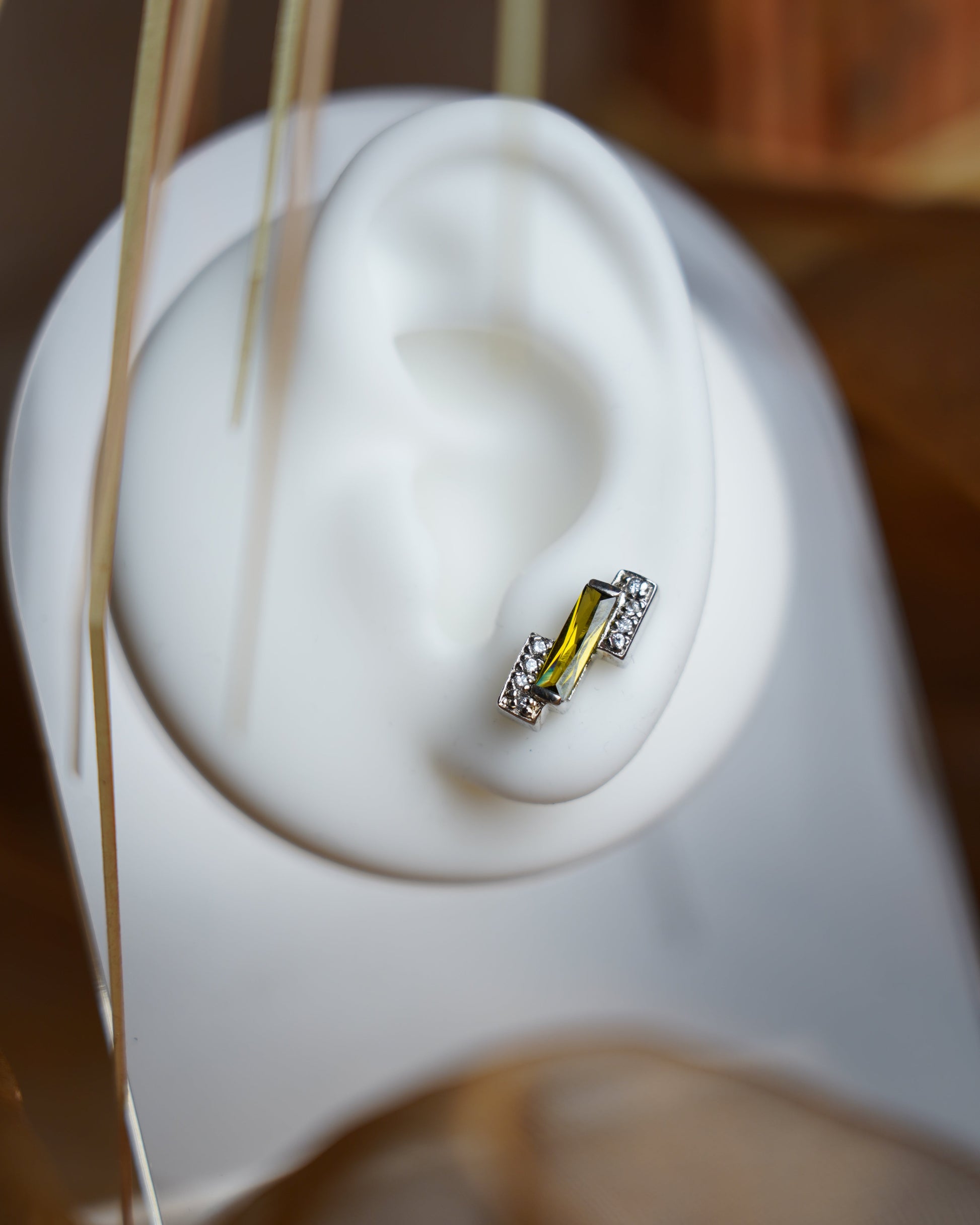 Ohrstecker aus 925/- Sterlingsilber mit olivgrünem rechteckigem Zierstein und funkelnden Zirkoniasteinen in elegantem Design.