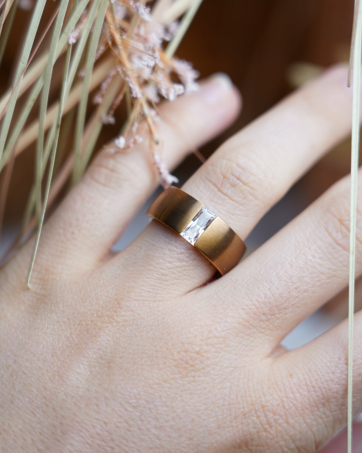 Rose Edge Ring aus rosévergoldetem Edelstahl mit breiter Ringschiene und länglichem Zirkoniastein im Zentrum.