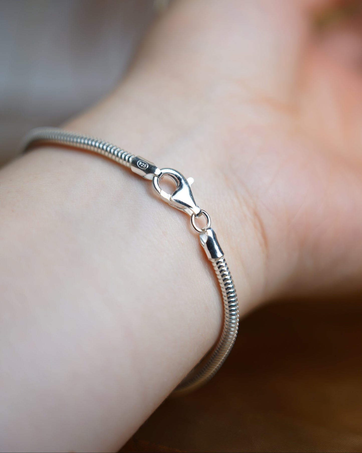 Schlangenarmband aus 925 Sterlingsilber mit glänzender Oberfläche auf Arm