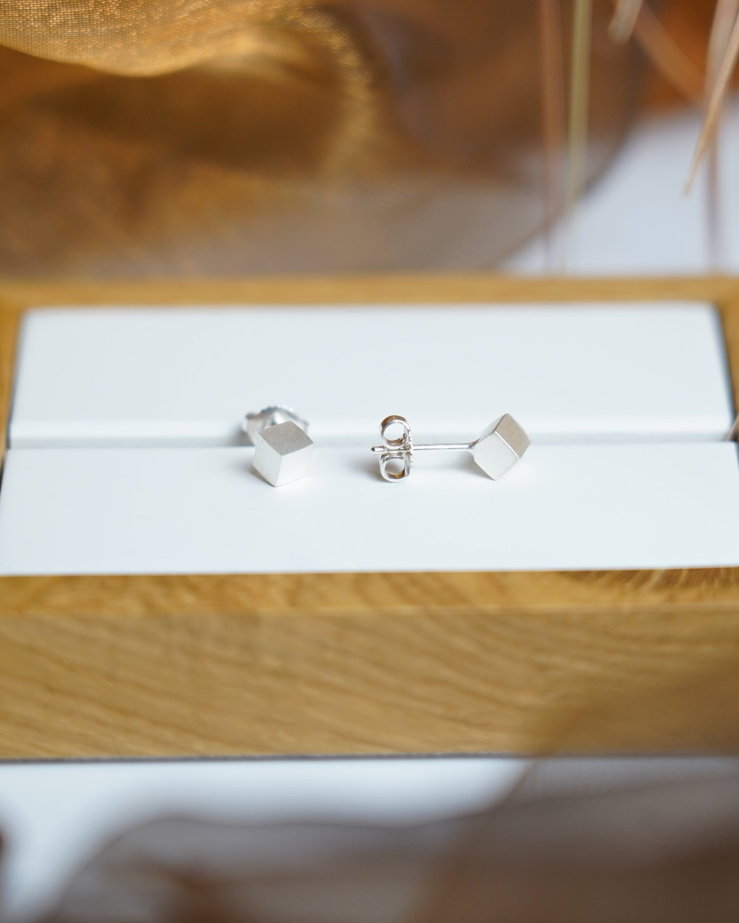 Würfelförmige Ohrstecker aus 925/- Sterlingsilber mit mattierter Oberfläche im minimalistischen geometrischen Design.
