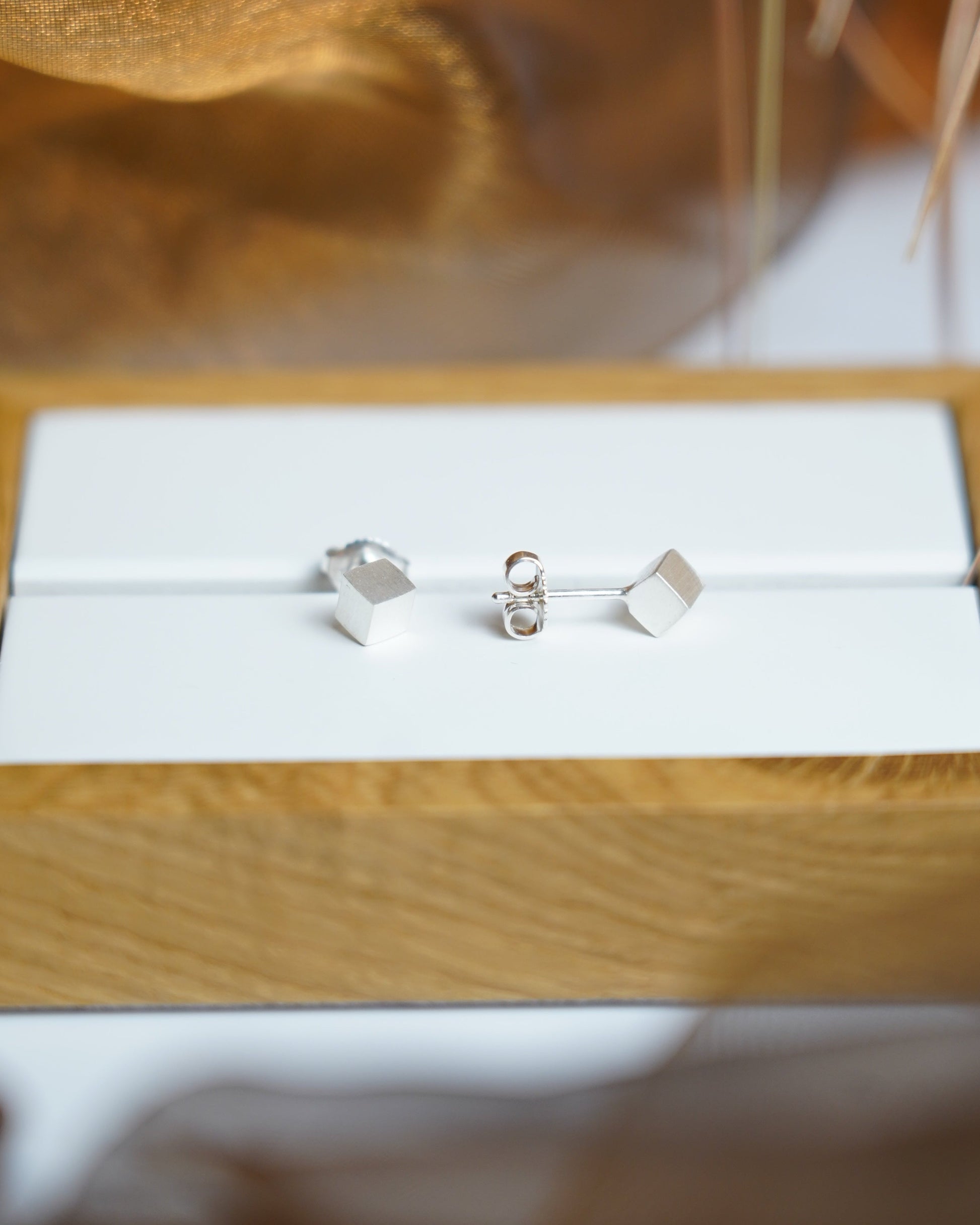 Würfelförmige Ohrstecker aus 925/- Sterlingsilber mit mattierter Oberfläche im minimalistischen geometrischen Design.
