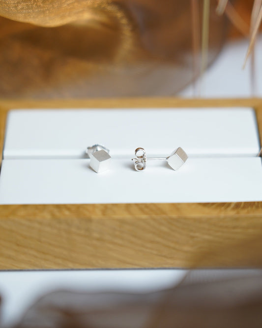 Würfelförmige Ohrstecker aus 925/- Sterlingsilber mit mattierter Oberfläche im minimalistischen geometrischen Design.